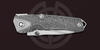 Несущие плашки рукояти из титана марки ВТ-6 украшены сложным фрезерованным рисунком «Альфа» авторства Николая Ломаченкова