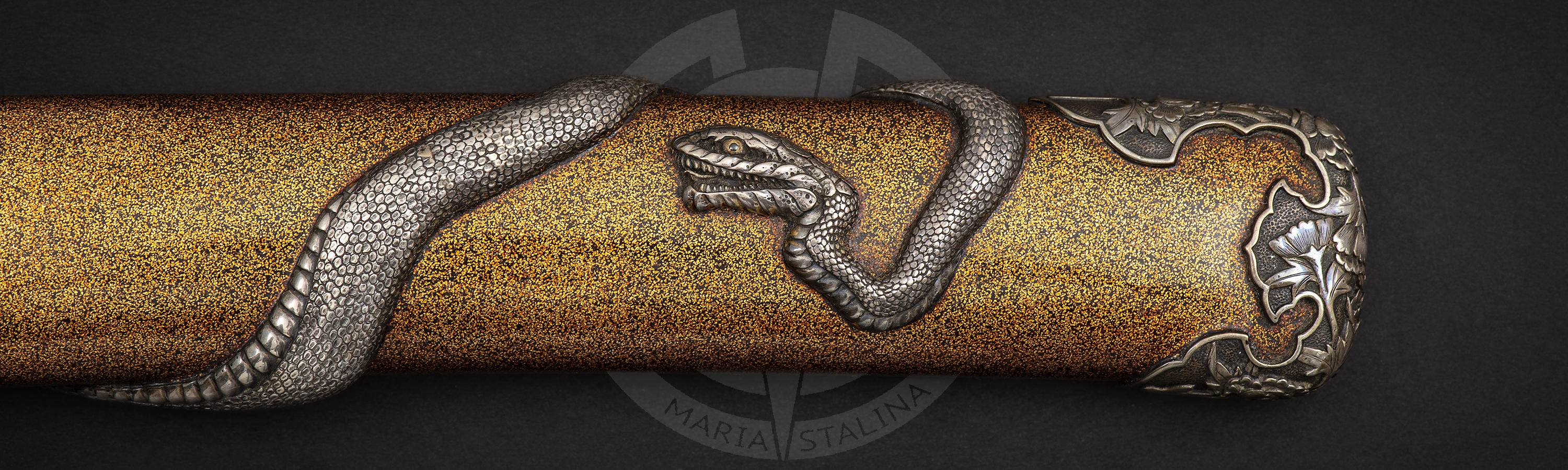 The snake wraps around the surface of the lacquer scabbard